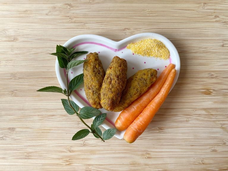 Rüebli-Rindfleisch-Bratlinge mit Karotten, Minze und Polenta auf einem herzförmigen Teller