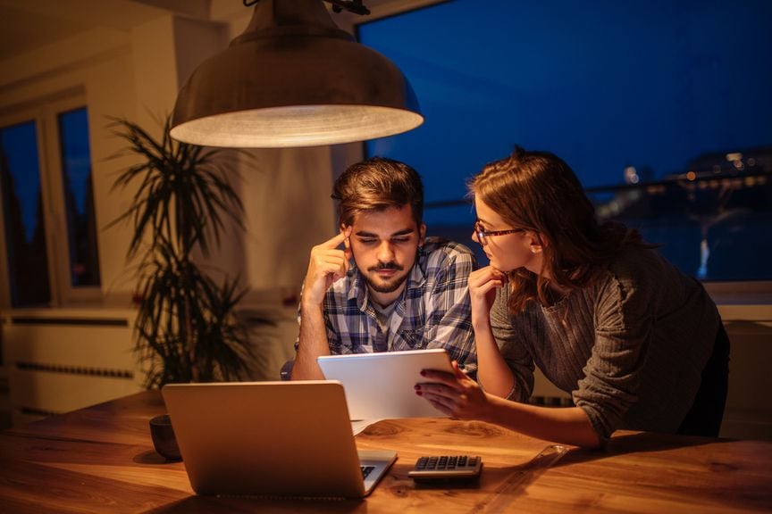 Paar unterhält sich, am Esstisch, über Finanzen