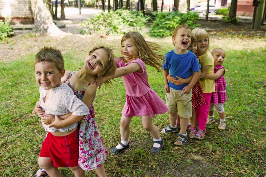 Fröhliche Kindergruppe spielt im Park