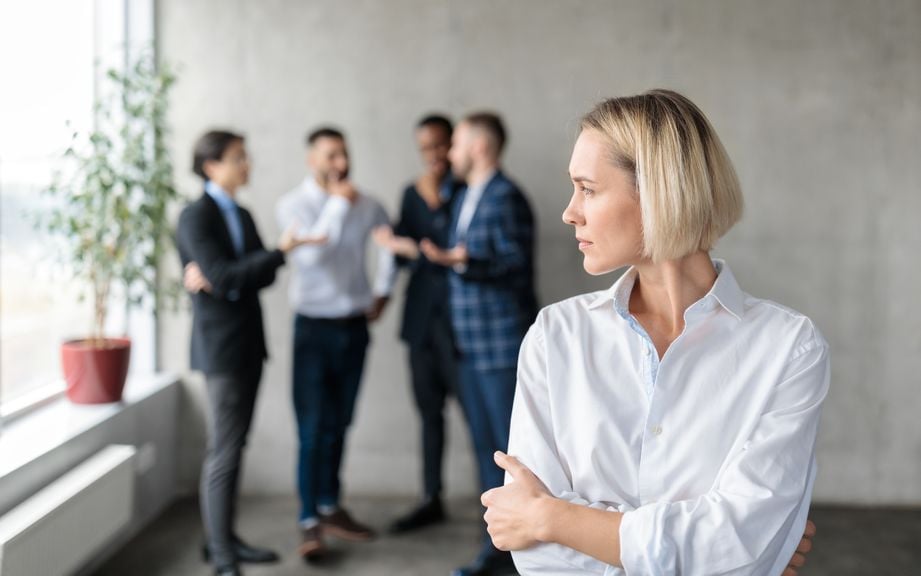 Männer sprechen sich bei der Arbeit hinter dem Rücken einer Frau ab