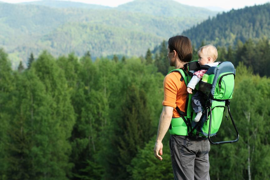 Vater in den Bergen mit Baby in der Rückentrage