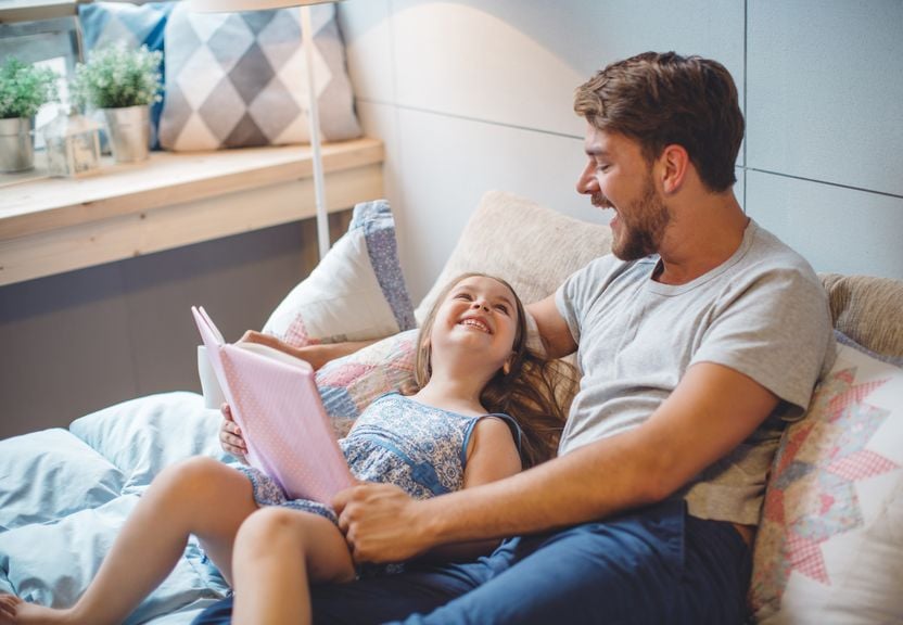 Kind und Vater vergnügen sich mit einem Buch 