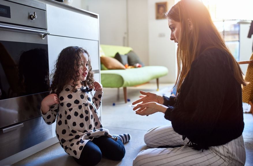 Mutter diskutiert mit Tochter auf dem Fussboden