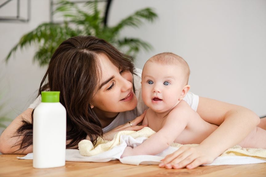 Mutter und ihr Baby mit Pflegeprodukt