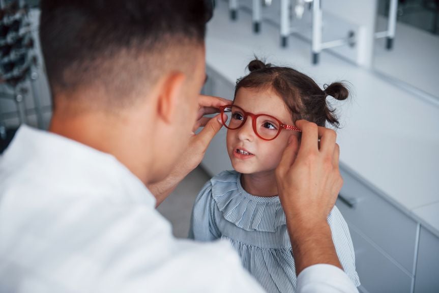 Mädchen probiert eine Brille an