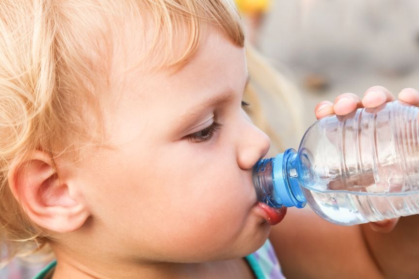 Kleiner Junge trinkt Wasser aus der Flasche