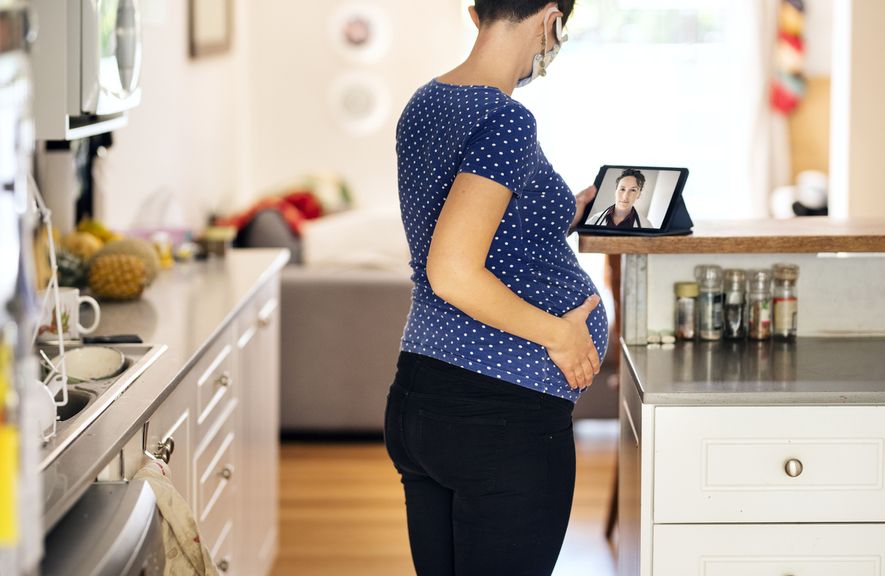 Schwangere mit Mundschutz bekommt Beratung per Video