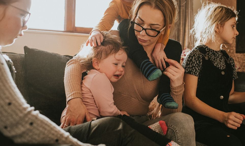 Mutter mit vier Kindern tröstet Mädchen