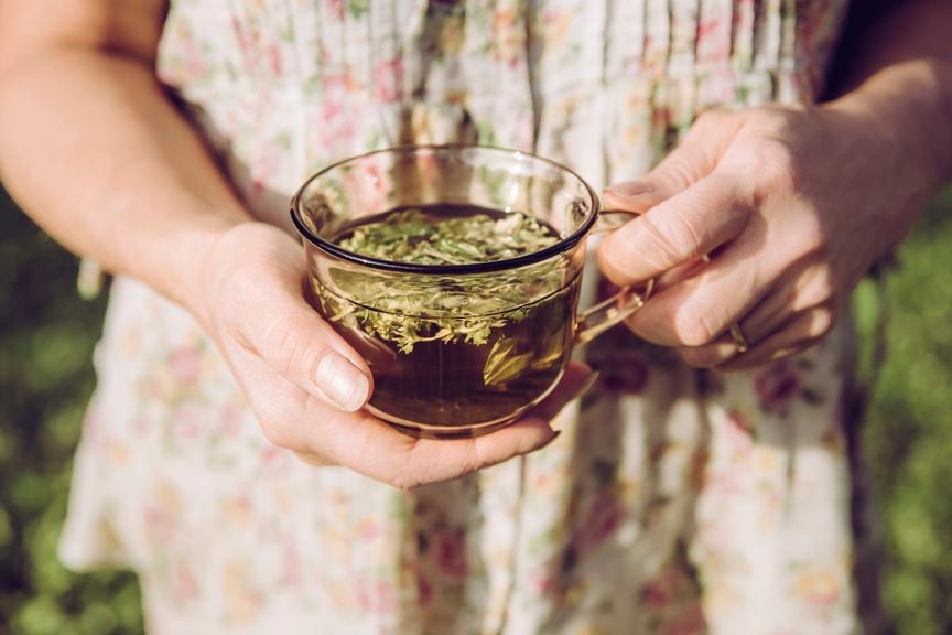 Frau hält Tasse mit Kräutertee