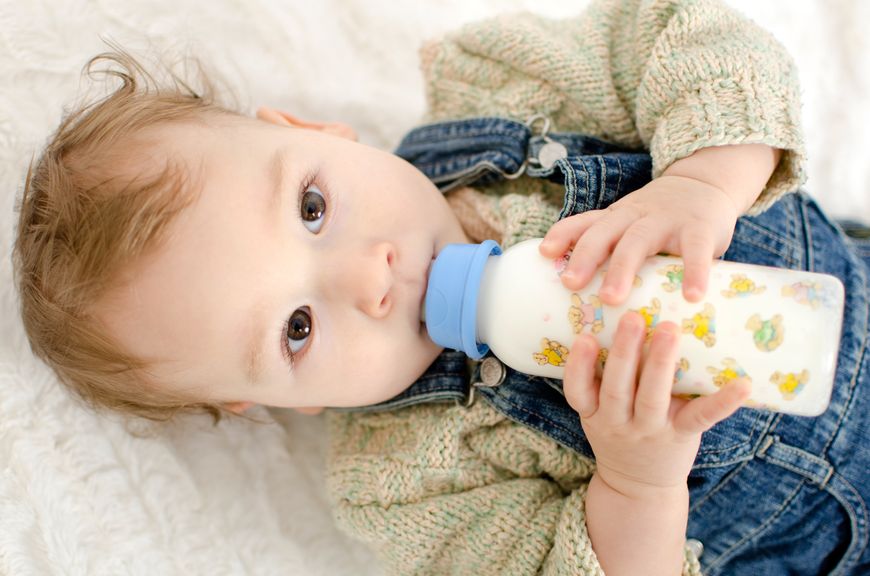 Baby im liegen, trinkt aus der Schoppenflasche