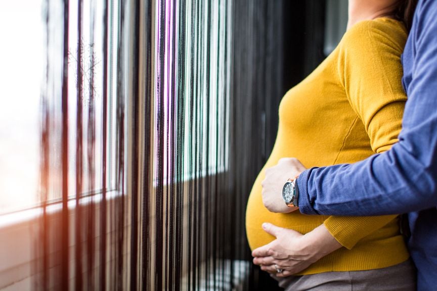 Männerhände umfassen den Bauch einer Schwangeren