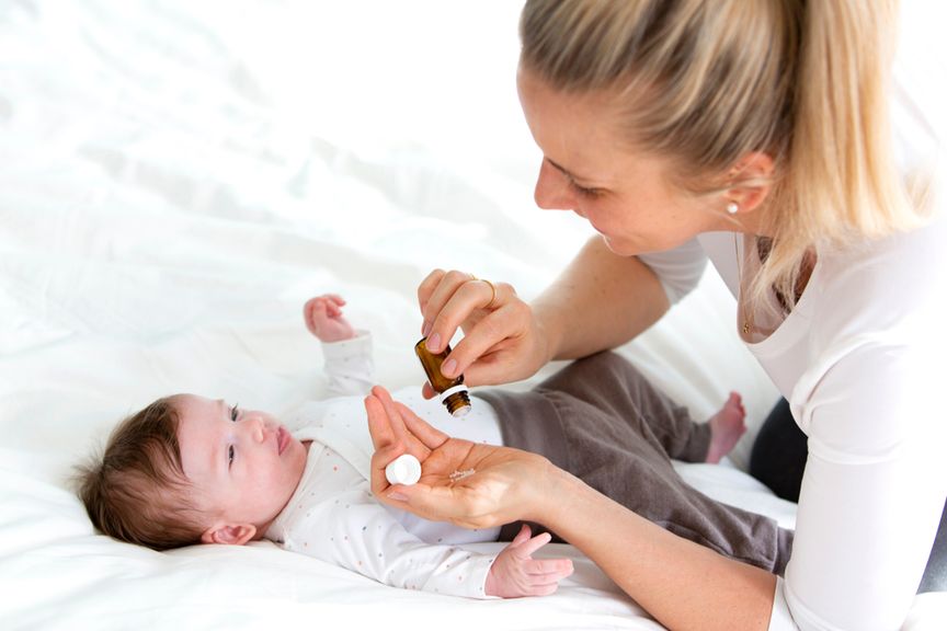 Mutter gibt ihrem Baby homöopathische Globuli