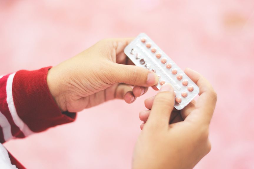 Frau mit Pillenblister in der Hand