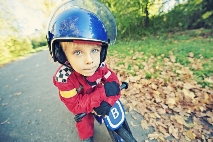 Junge mit BMX-Anzug, Helm und Fahrrad
