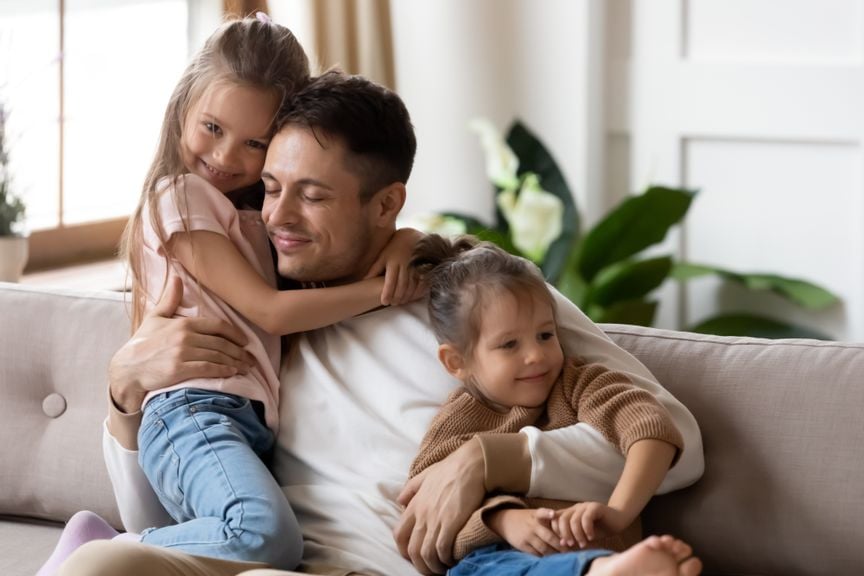 Zufriedender Vater mit Kindern auf dem Sofa