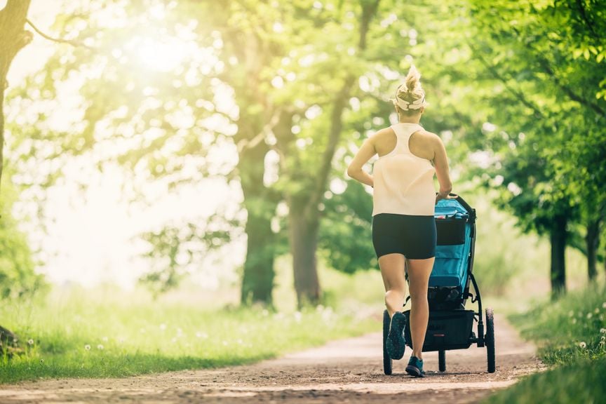 Mutter joggt mit Kinderwagen 