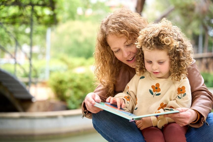 Mutter schaut mit ihrem Kind ein Bilderbuch an