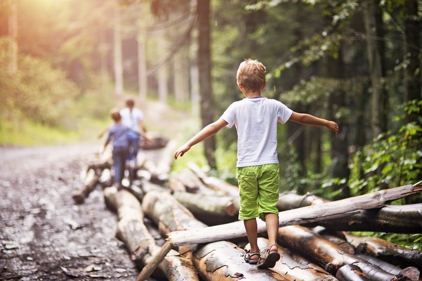 Kinder balancieren über Baumsämme