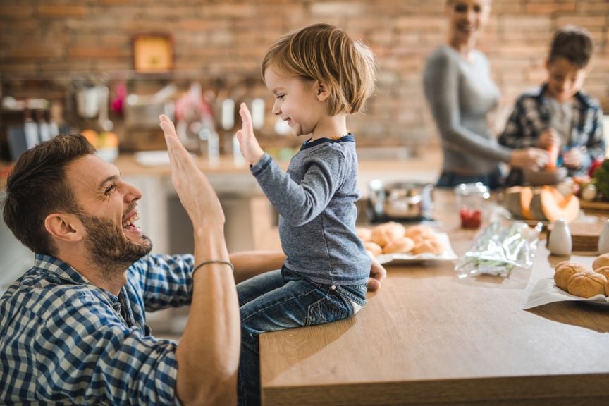 Vater mach Highfive mit kleinem Sohn