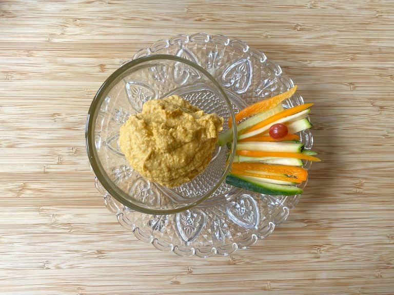 Hummus mit Peperoni mit Gemüsesticks und Cherrytomate auf Glasgeschirr