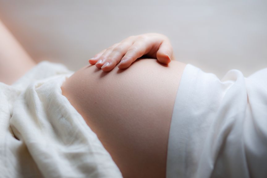 Schwangere mit Hand auf dem Bauch 