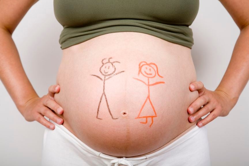 Babybauch mit Strichmännchen und -weibchen