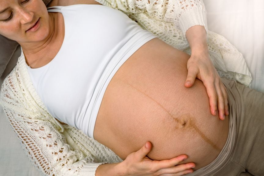 Schwangere hält sich den Bauch