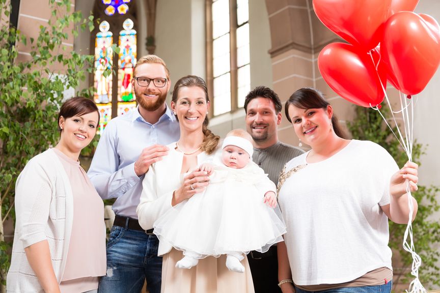 Eltern mit Baby im Taufkleid und Taufpaten