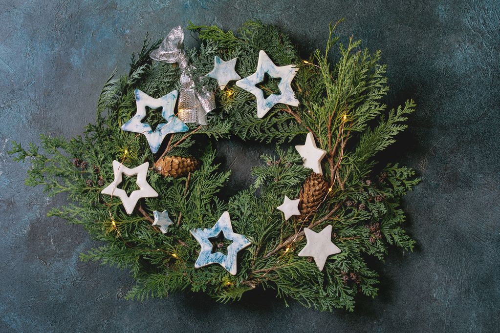 Weihnachtskranz aus Thujazweigen mit Sternen, Tannzapfen und Lichterdraht