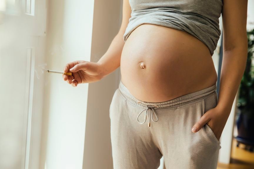 Schwangere mit Zigarette in der Hand