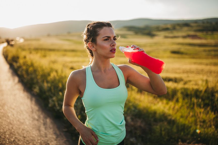 Joggerin mit rotem Drink