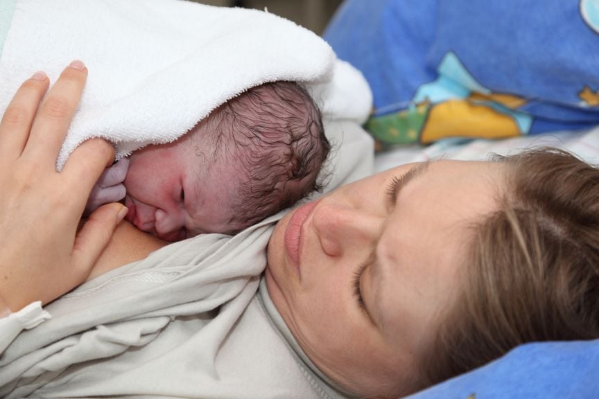 Neugeborenes Minuten nach der Geburt auf der Brust der Mutter