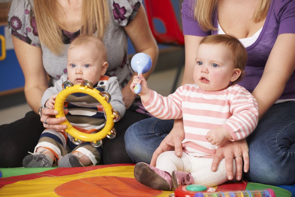 Baby mit Musikinstrumenten am Boden sitzend