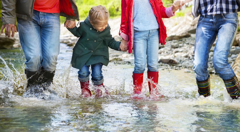 Familie mit Gummistiefeln im Wasser