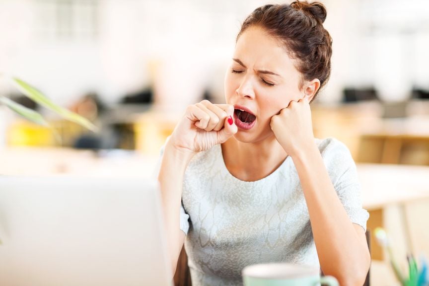 Frau im Büro gähnt 