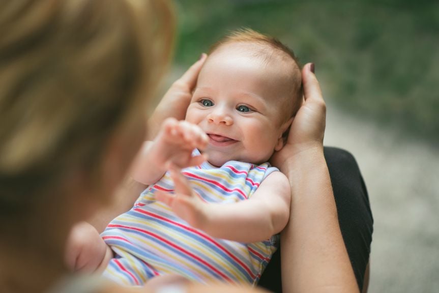 Säugling lächelt Mama an