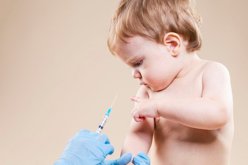 Kleinkind streckt den Finger aus zur Impfspritze