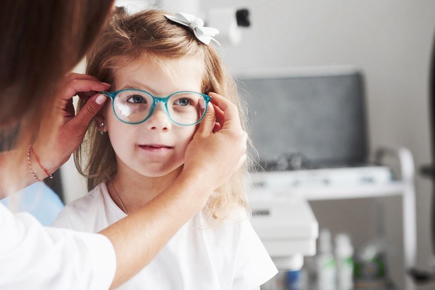 Mädchen probiert eine Brille an