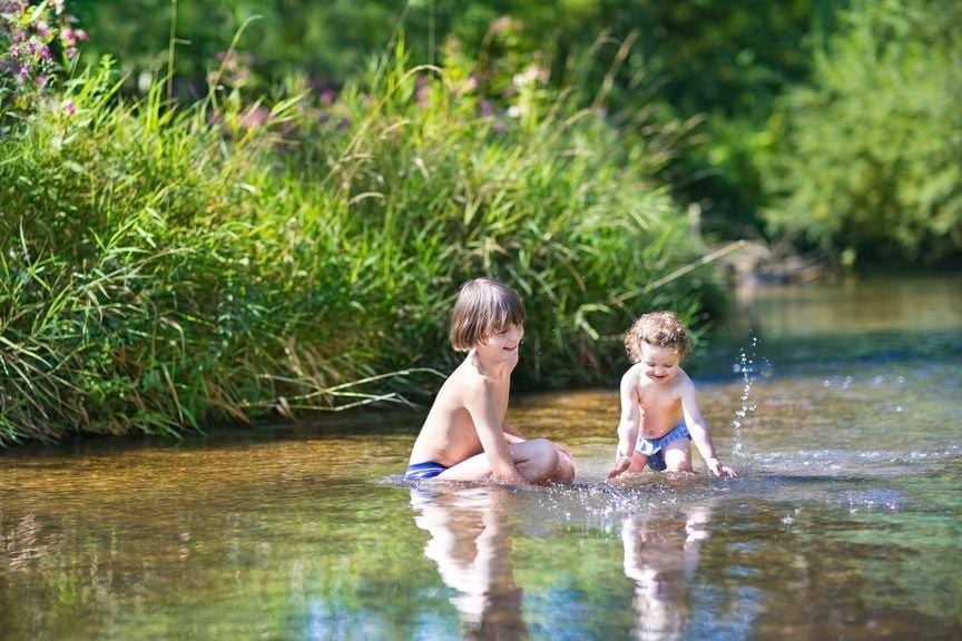 Zwei Kinder baden im See
