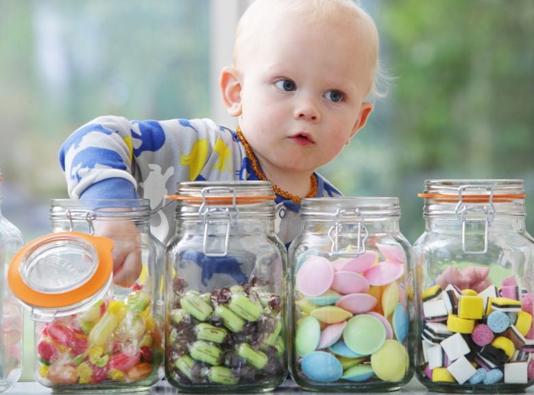 Baby nimmt Süssigkeiten aus dem Glas