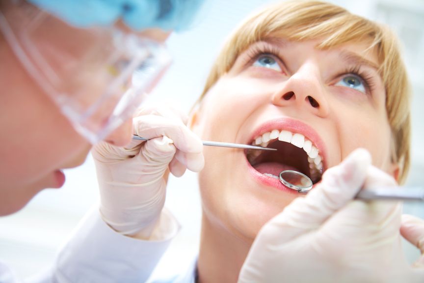 Zahnarzt kontrolliert die Zähne einer Frau