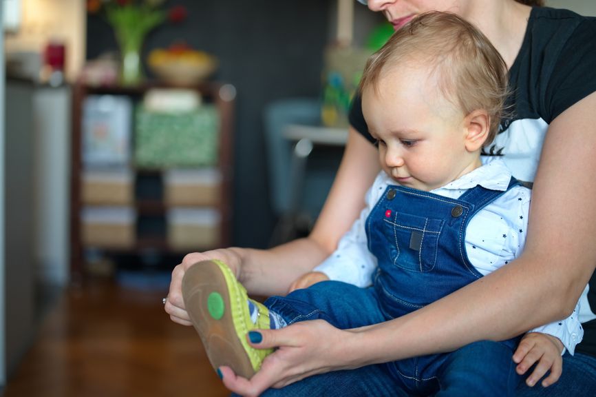 Mutter zieht Baby Schuhe an