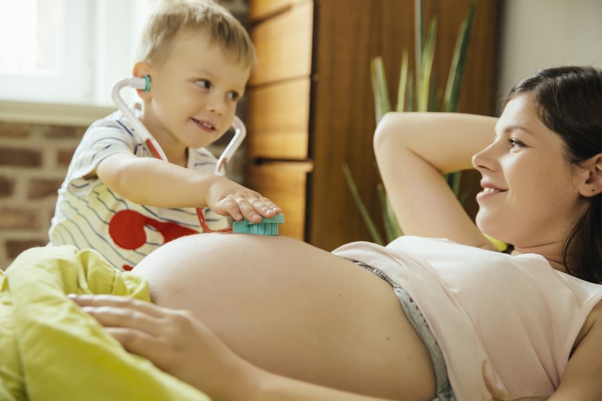 Sohn untersucht die schwangere Mutter