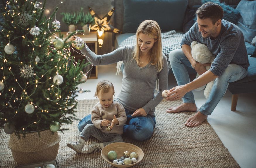 Familie schmückt den Weihnachtsbaum,[Translate to FR:] IStock 861249950