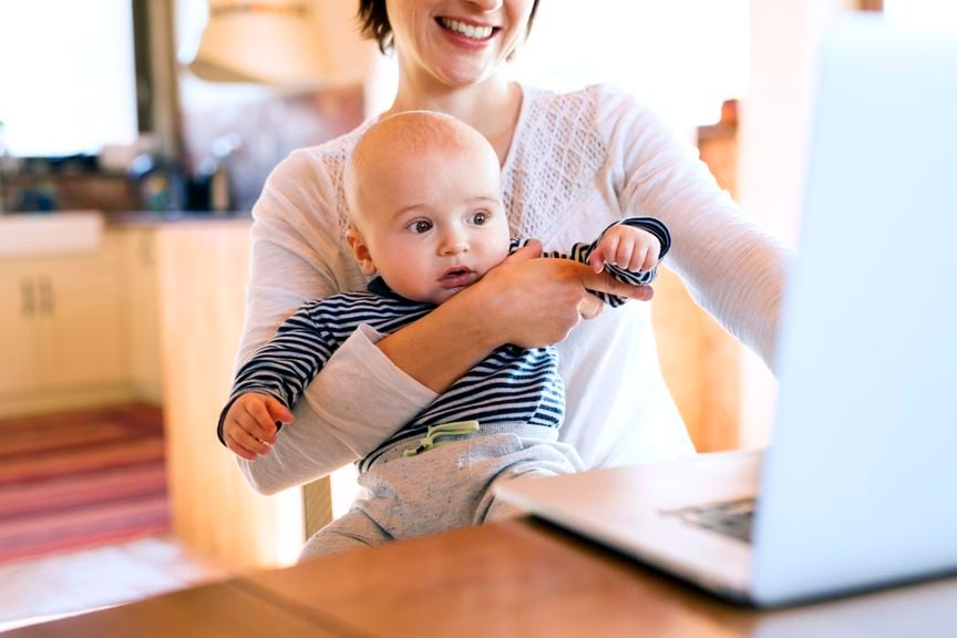 Mutter mit Baby vor dem Laptop