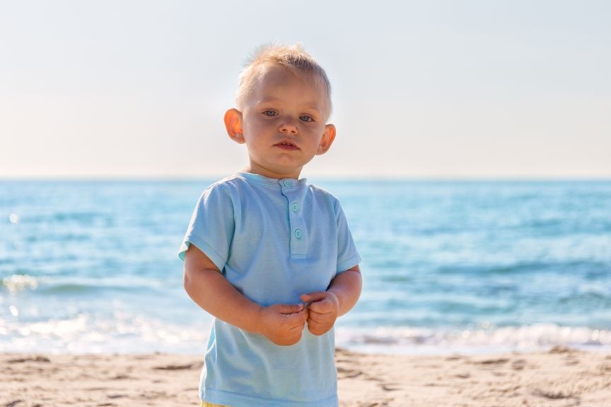 Junge mit abstehenden Ohren am Strand