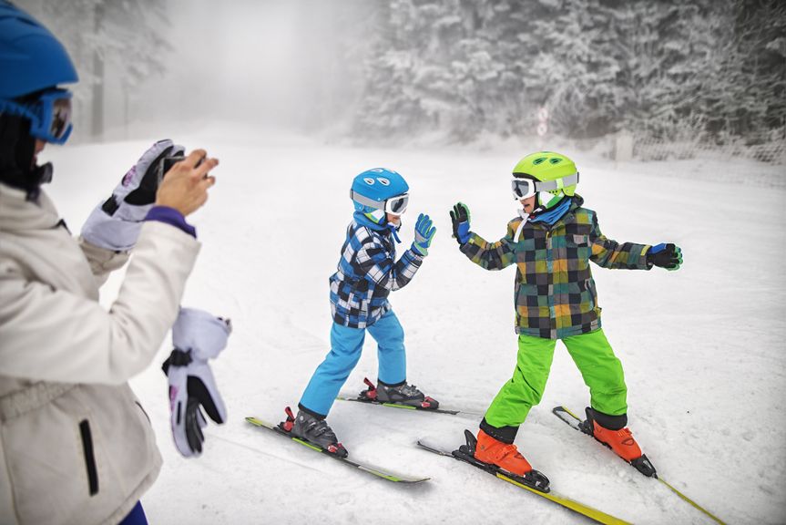 Mutter fotografiert Kinder beim Skifahren