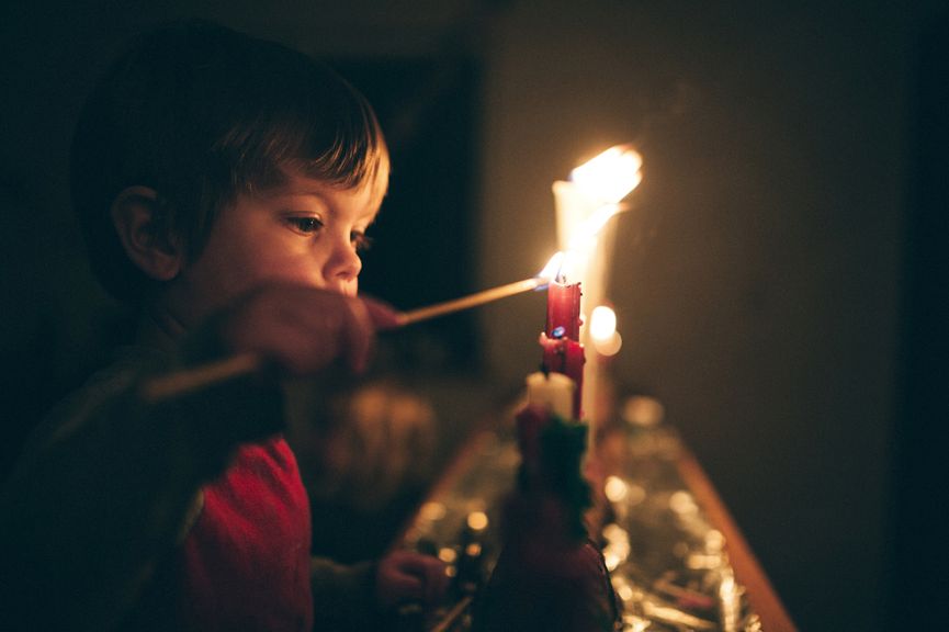 Junge zündet eine Kerze an