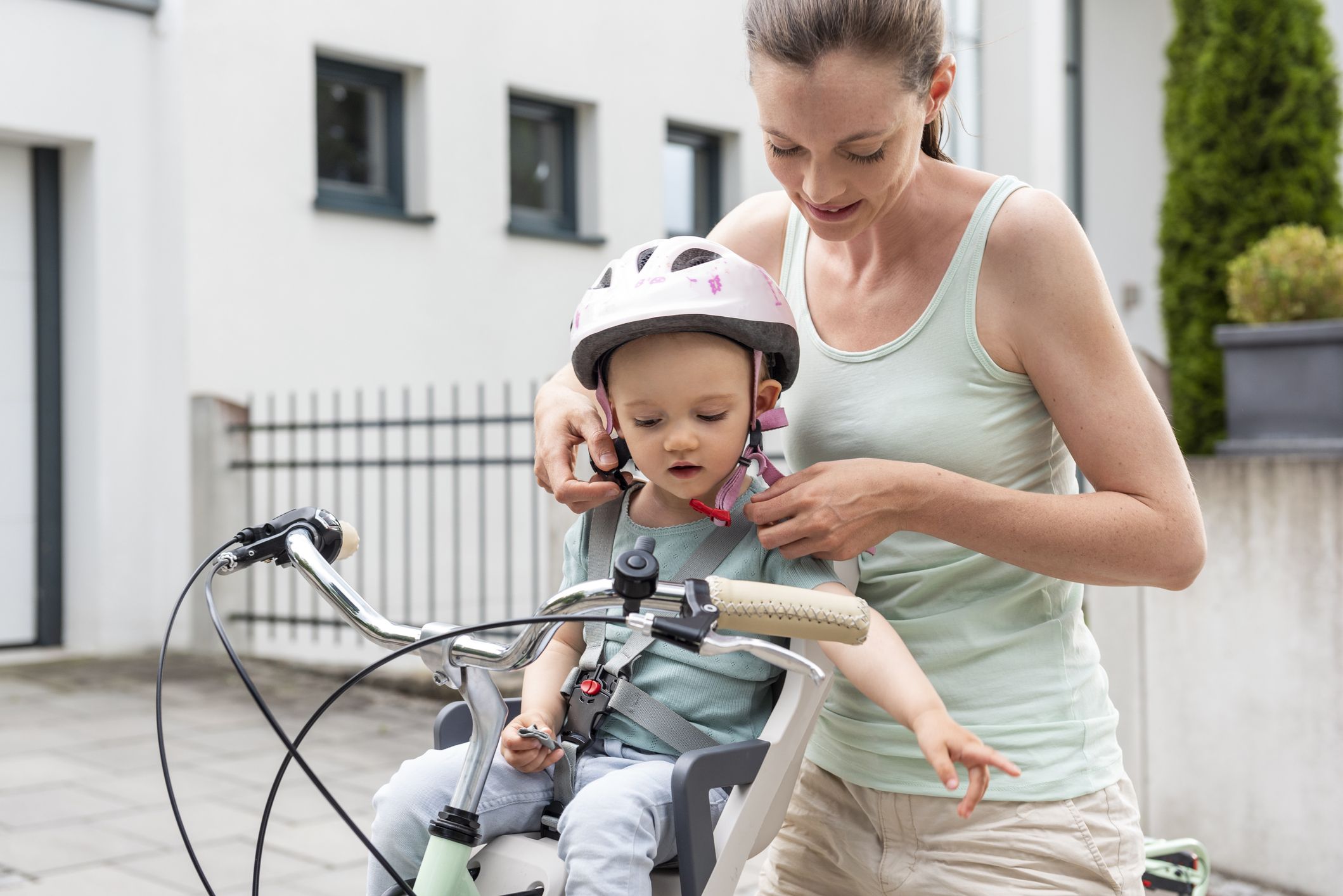 Mutter zieht Kind den Helm an