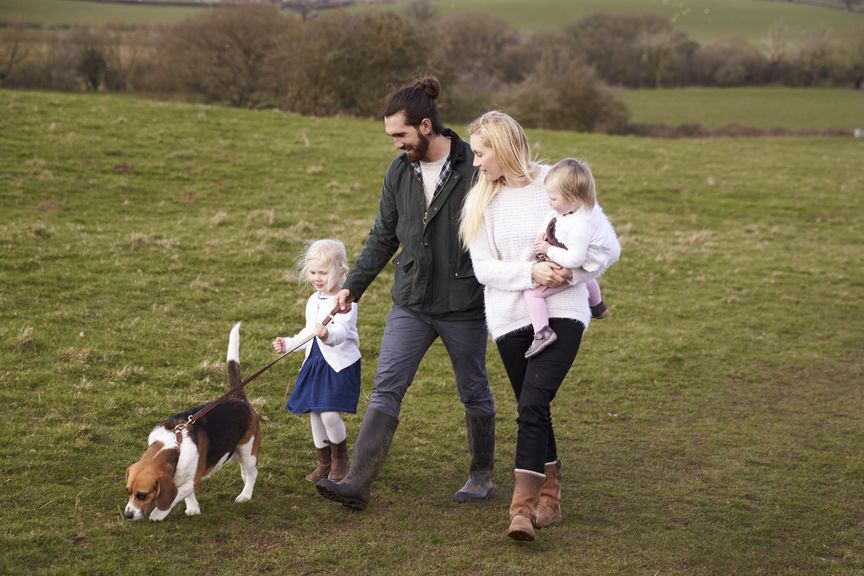 Familie mit zwei Kindern und Hund beim Spaziergang 